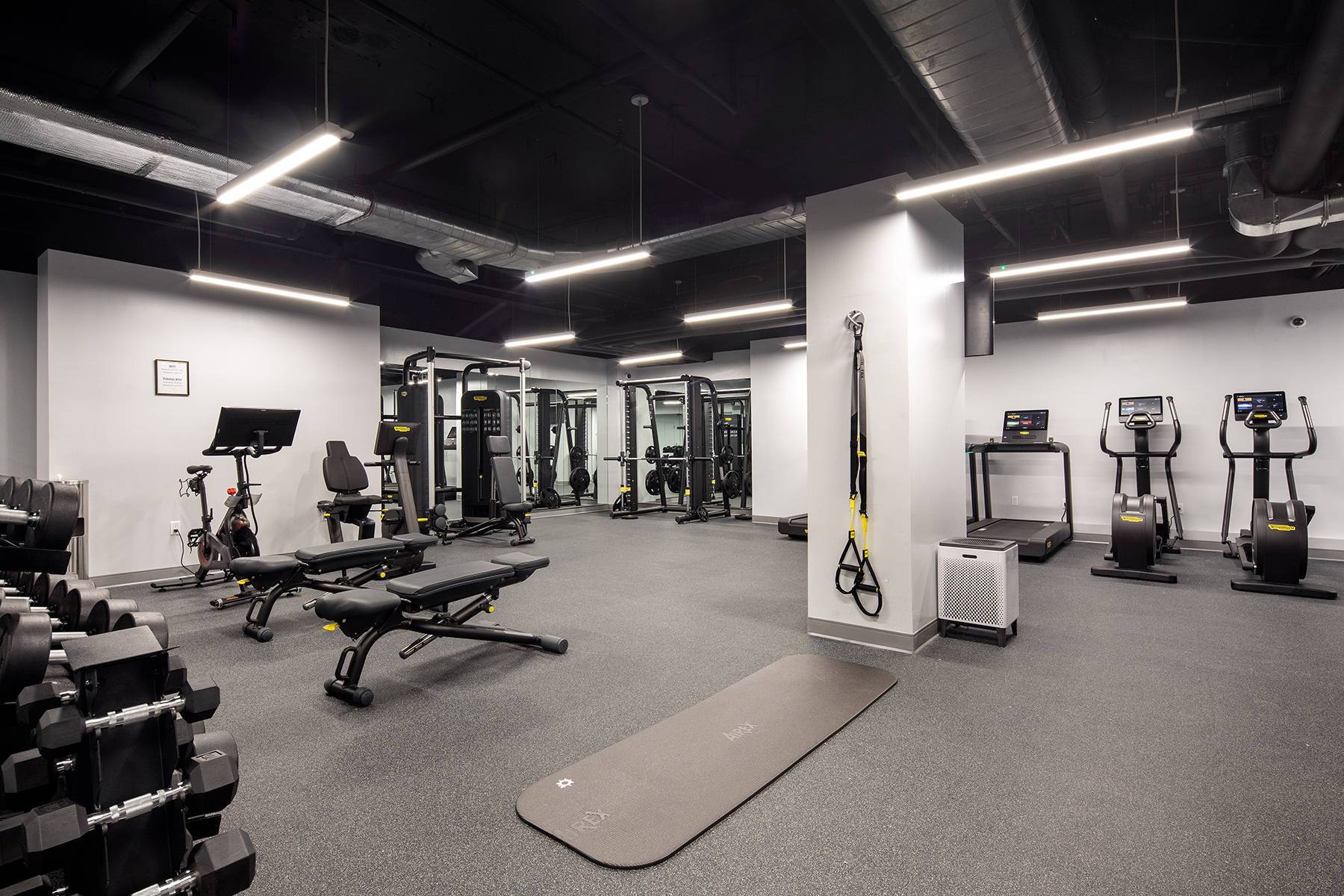 Large fitness center with various weights, fitness machines, bikes, resistance bands station and more