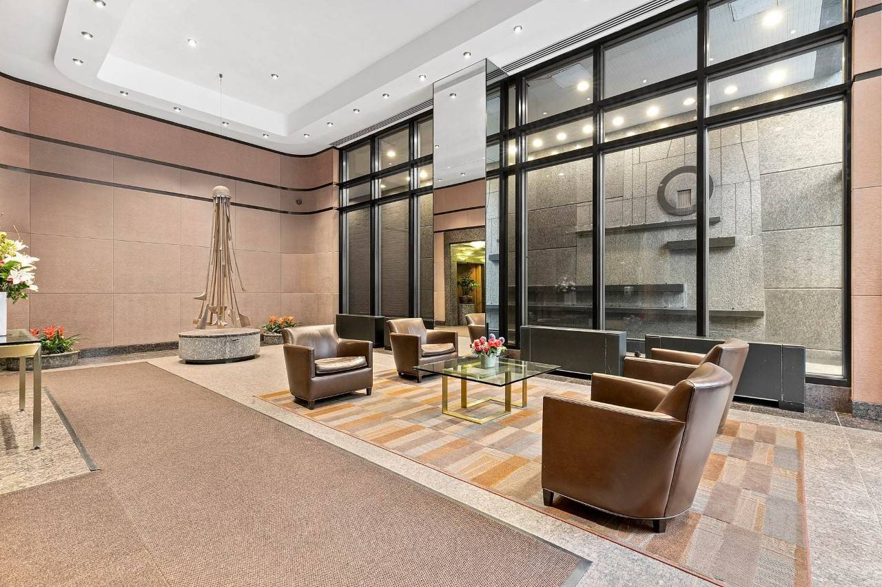 Large open lobby with high ceilings, seating, coffee table with flowers at 150 East 57th Street
