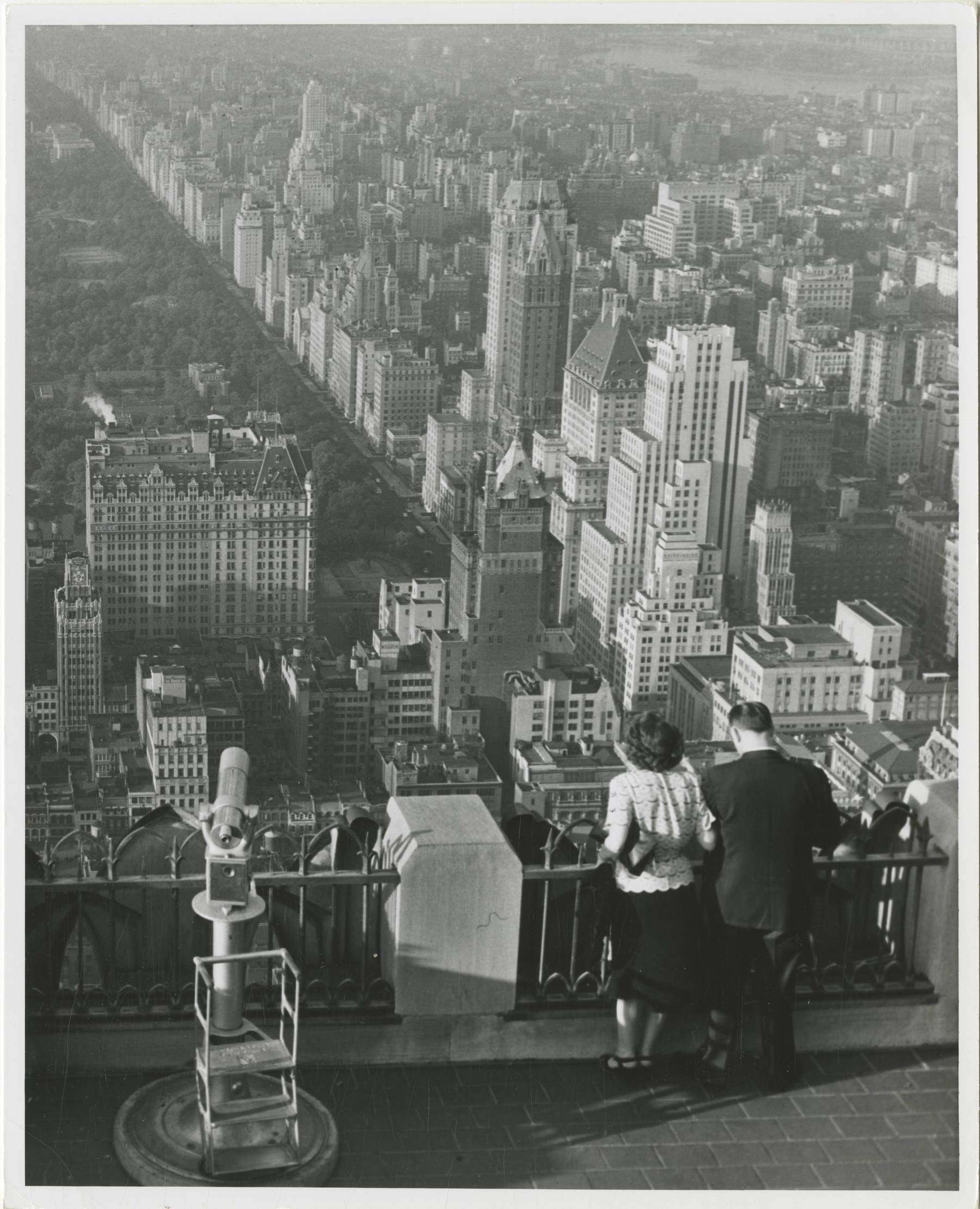 B&w photo of man and woman standing on roof of the RCA building